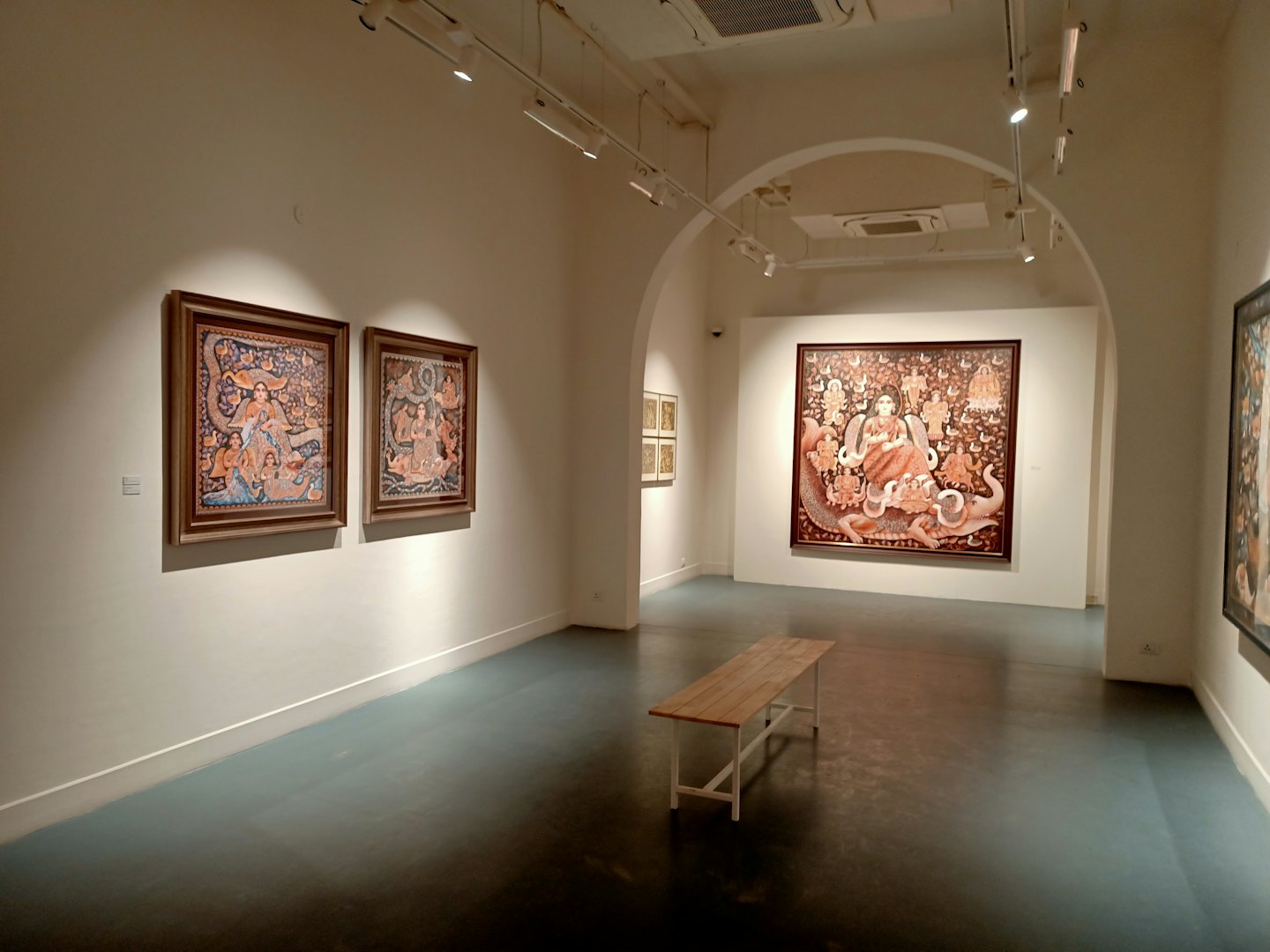 En träbänk står i ett modernt vitt konstgalleri.